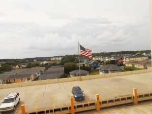 Roof Parking lot with american flag and garden city in the background