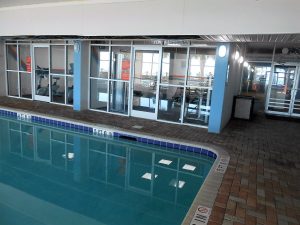 Indoor swimming pool with view of fitness room